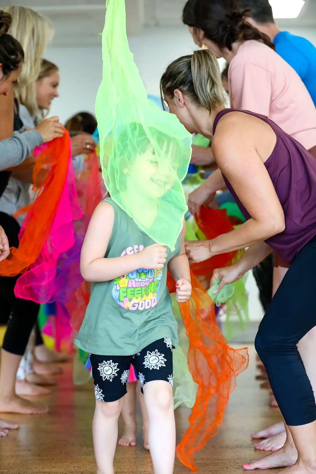 An adult and child sharing a colourful Rainbow Yoga activity