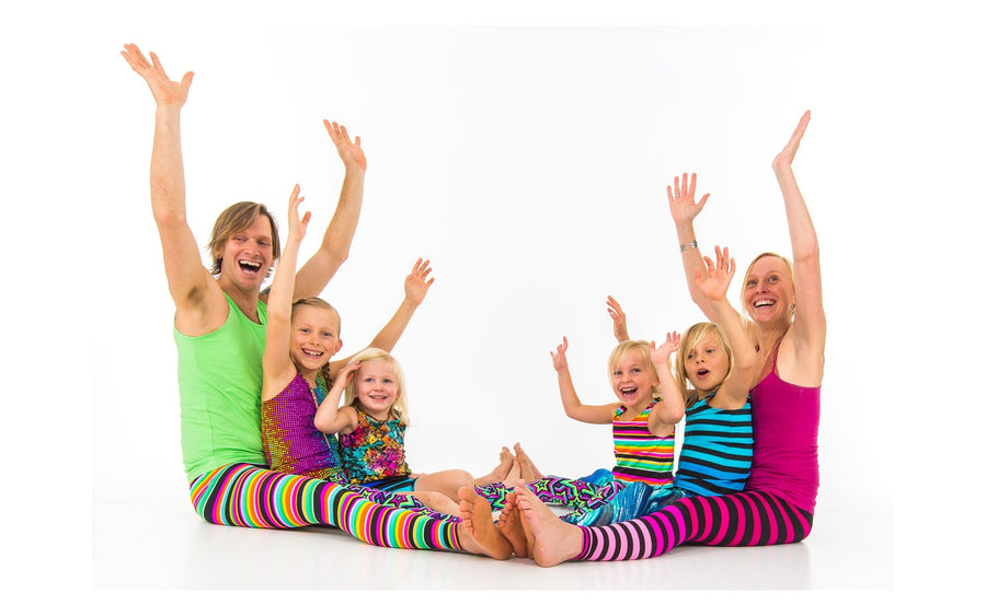 Adults and children sharing a playful seated movement activity in the Rainbow Yoga archive.