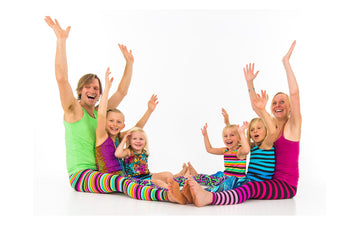 Adults and children sharing a playful seated Rainbow Yoga movement activity