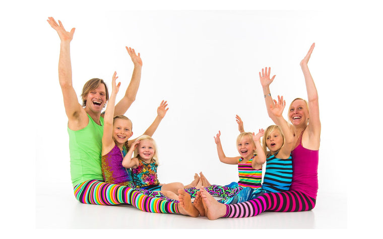 Adults and children sharing a playful seated Rainbow Yoga movement activity