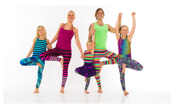 Adults and children holding hands in a shared standing balance, from the Rainbow Yoga photo archive.