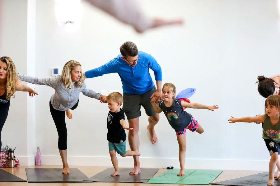 Rainbow Yoga students practicing partner balance and trust together