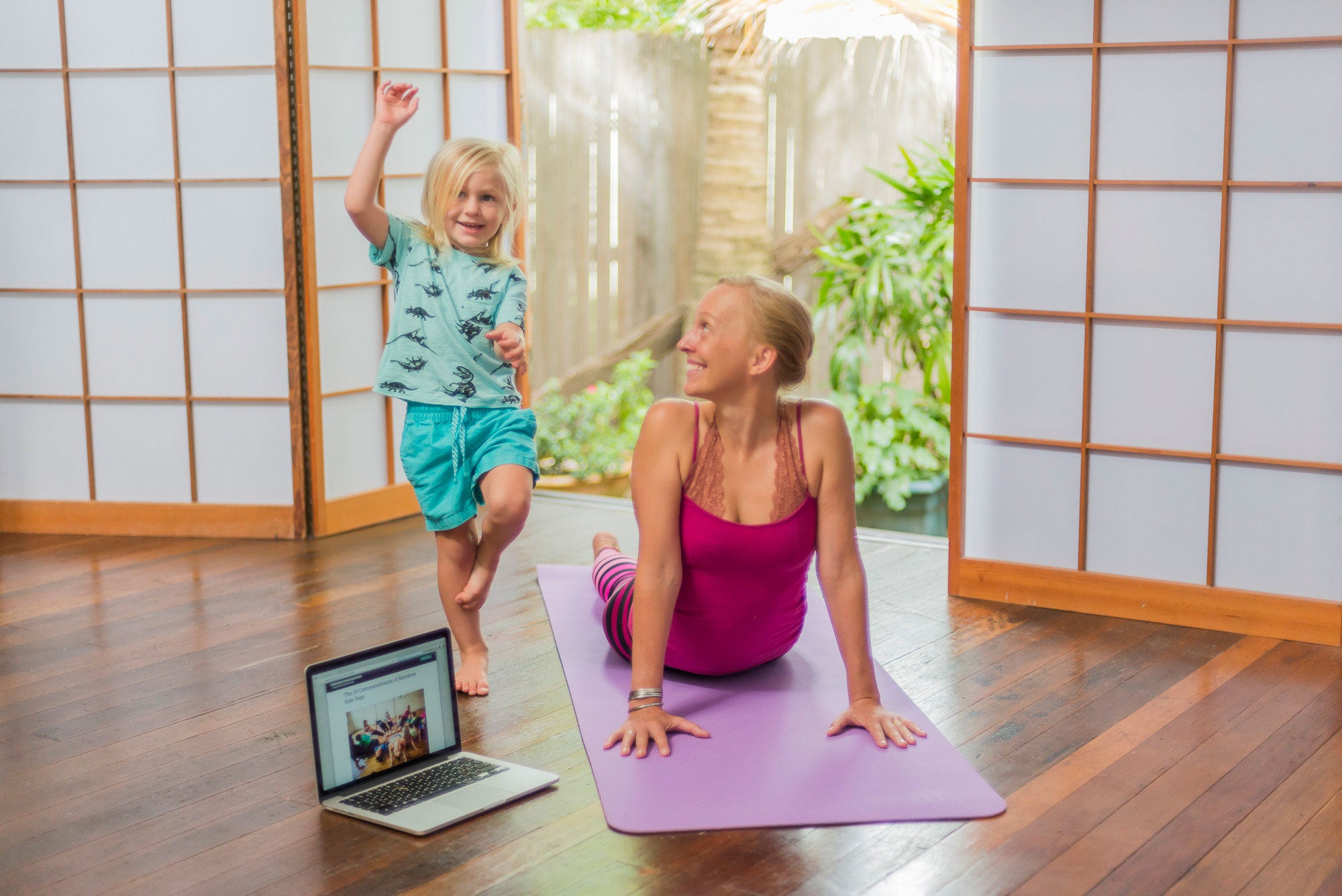 A child and adult practising with Rainbow Yoga online learning at home