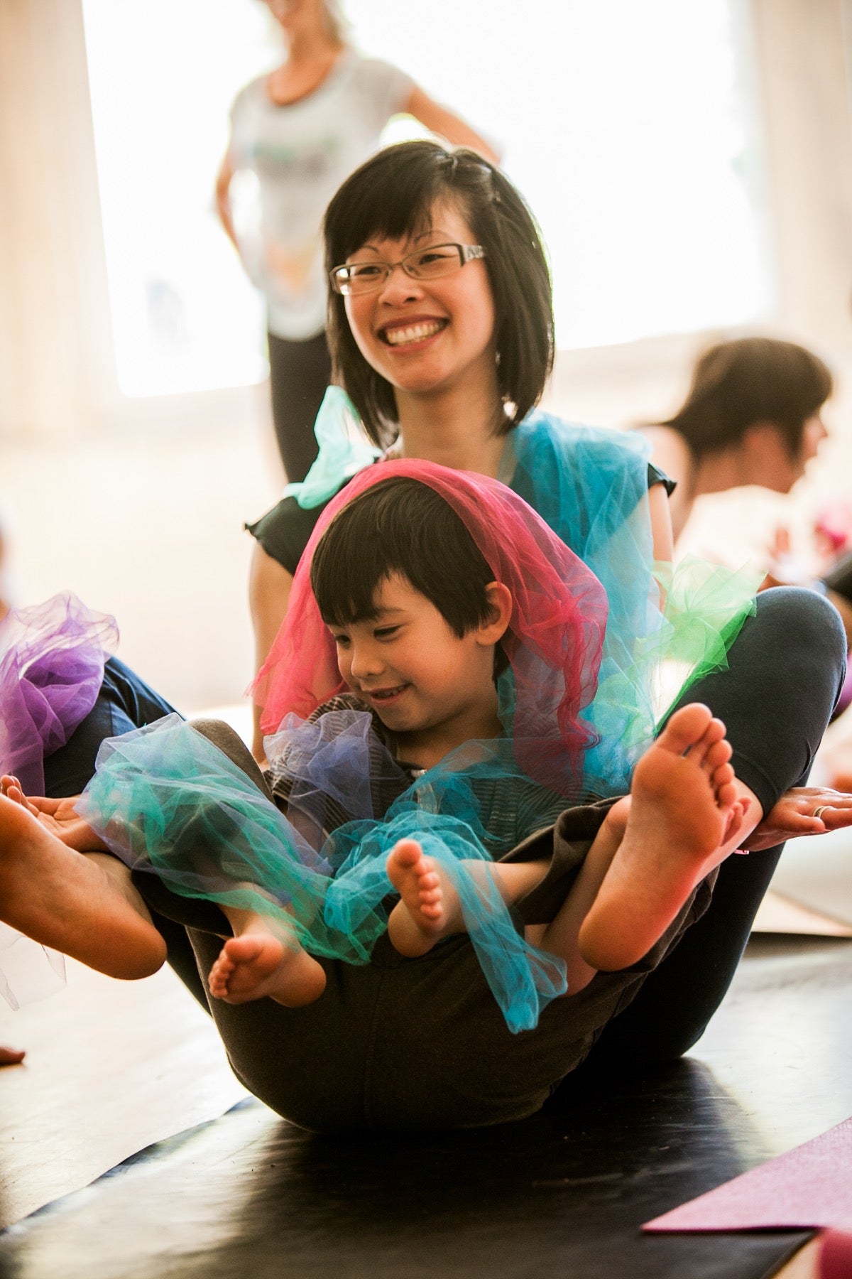A smiling adult and child sharing a colourful Rainbow Yoga moment