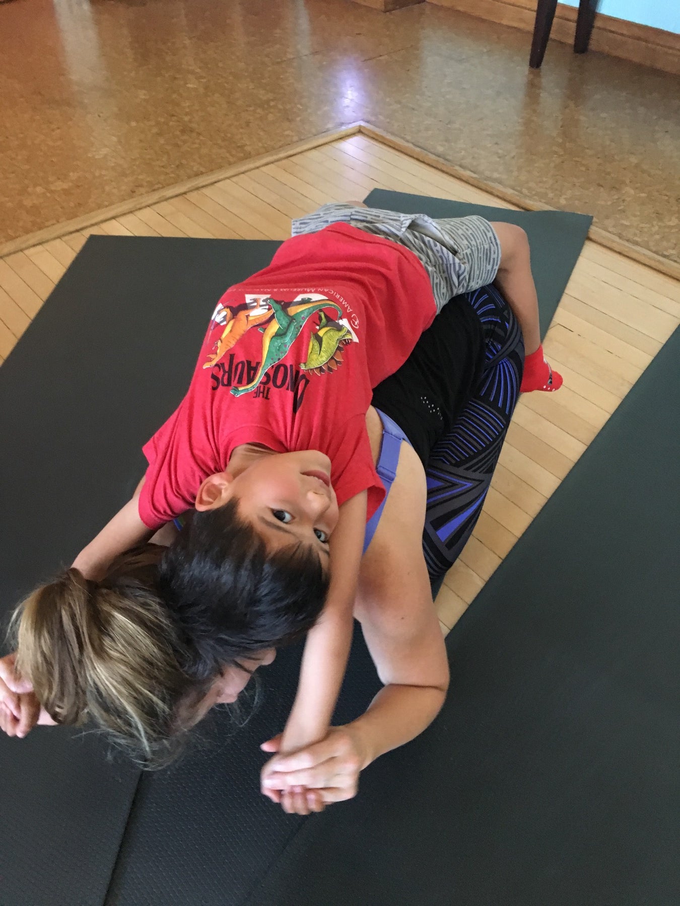 A child laughing during playful family yoga connection with Rainbow Yoga