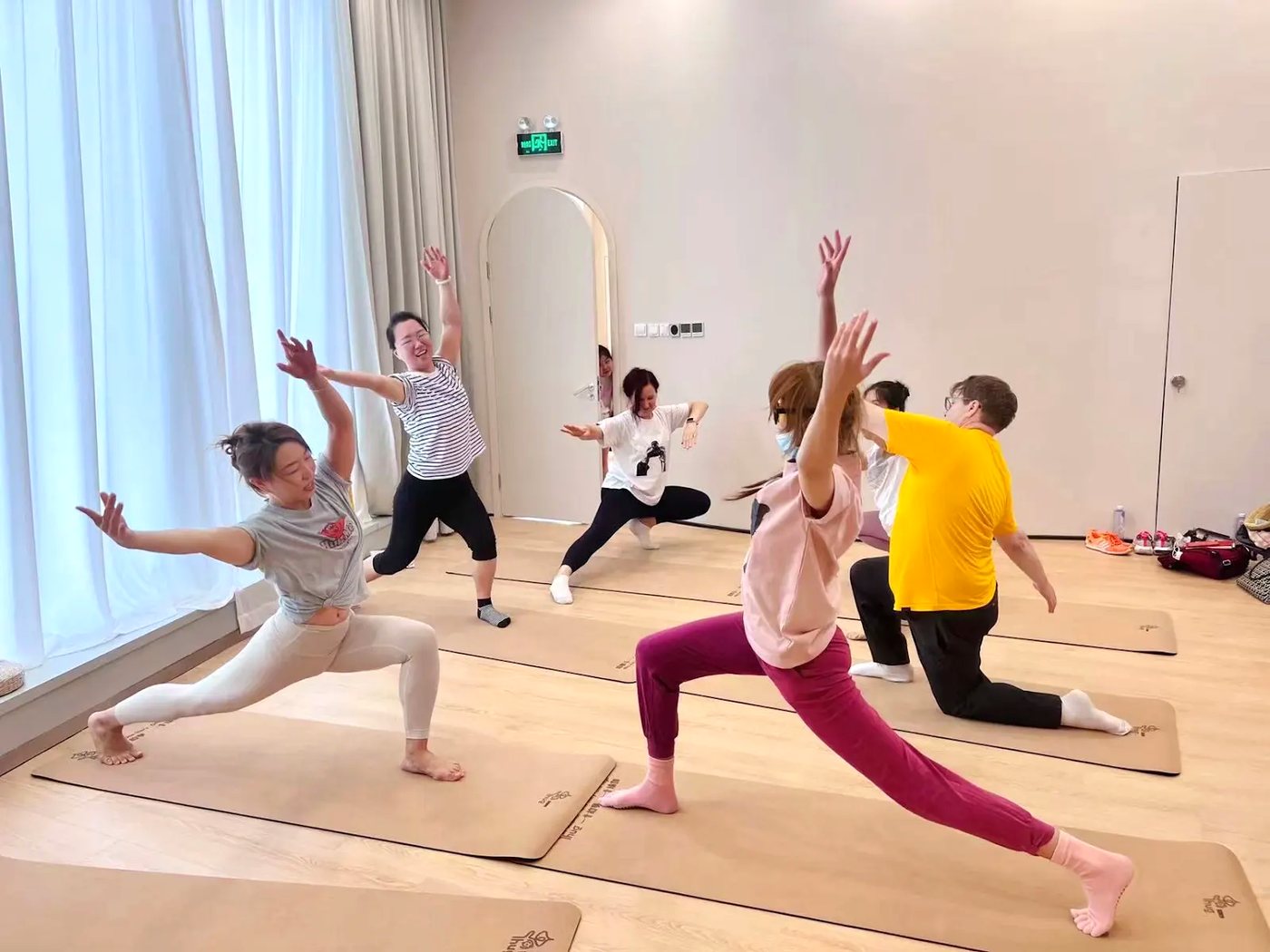 Rainbow Yoga trainees moving together in a bright group training