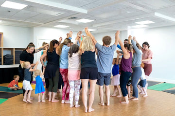 Rainbow Yoga trainees lifting their hearts together in a connected circle