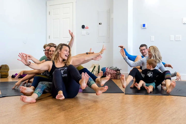 Adults smiling and connecting during a Rainbow Yoga training