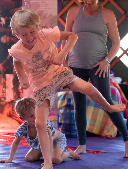 Children moving through a playful group yoga tunnel